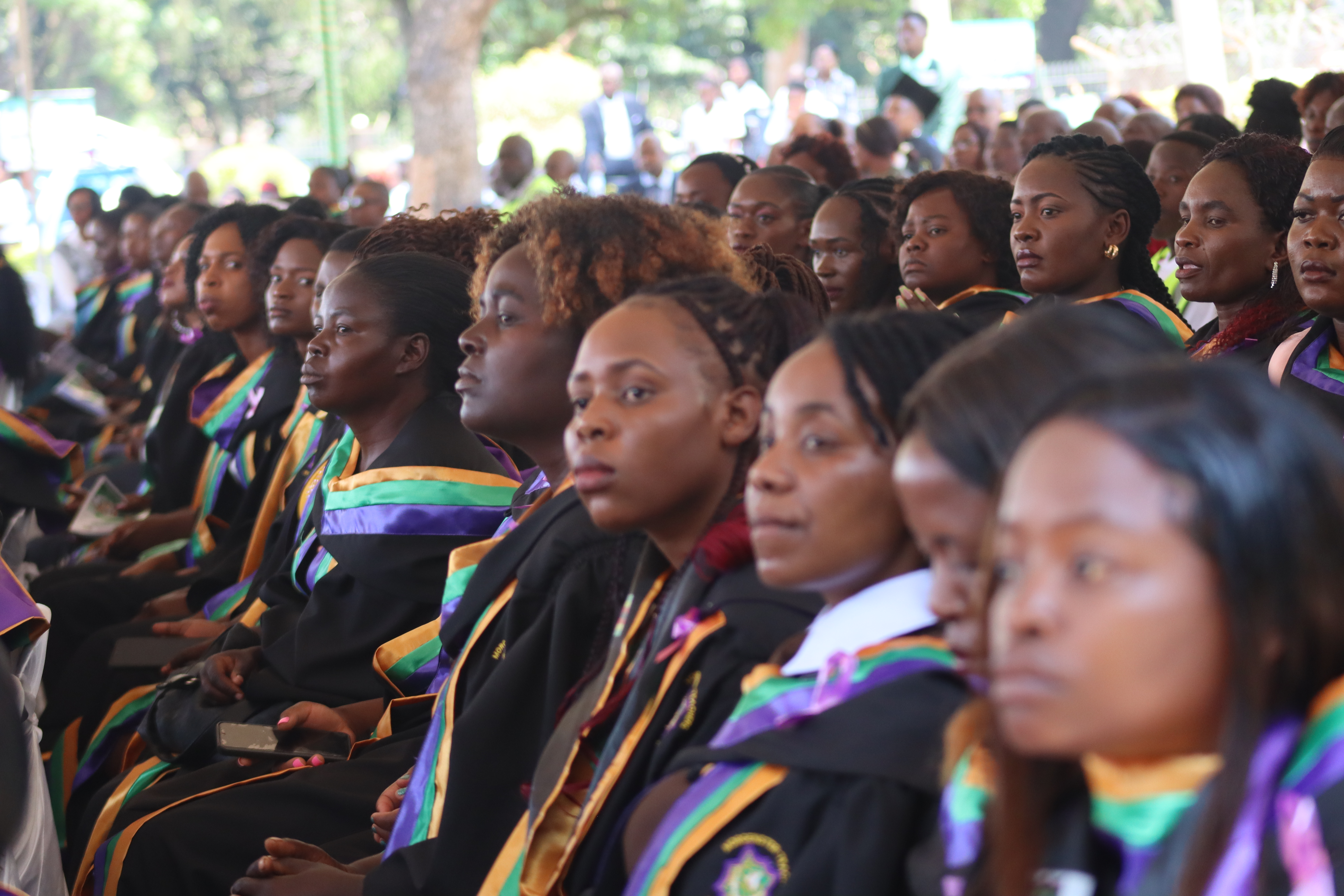 Graduates celebrating at an outdoor college ceremony